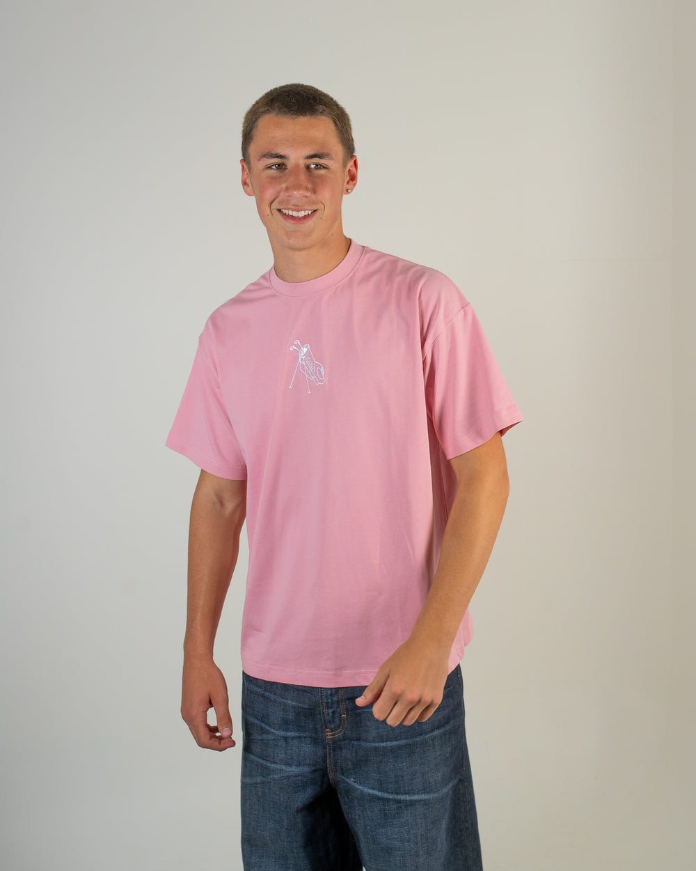 Person wearing a pink t-shirt with a logo on a plain background